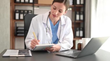 Tıbbi teknoloji konsepti. Doktor ofiste dizüstü bilgisayar ve steteskopla çalışıyor.