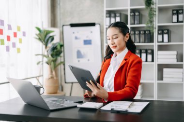 Woman freelancer is working her job on computer tablet and laptop, Doing accounting analysis report real estate investment data, Financial at modern office