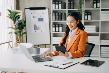 Bir ofis masası, vergi, rapor, muhasebe, istatistik ve analitik araştırma konseptinde matematik finansmanı için tablet ve dizüstü bilgisayar kullanan iş kadını