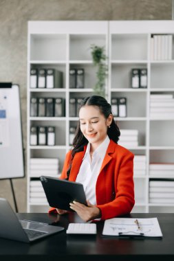 Woman freelancer is working her job on computer tablet and laptop, Doing accounting analysis report real estate investment data, Financial at modern office