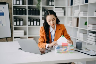Asyalı kadın migren ağrısı çekiyor. Modern ofiste dizüstü bilgisayar üzerinde çalışırken çok çalışan iş kadını finansörü..