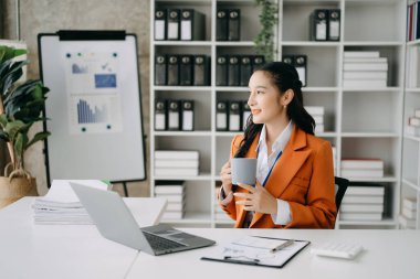 Bir ofis masasında matematik finansmanı, vergi, rapor, muhasebe, istatistik ve analitik araştırma kavramını kullanan iş kadını
