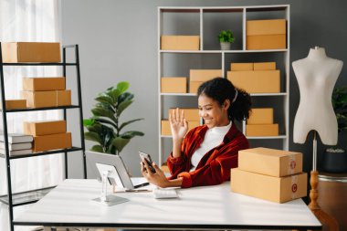 Küçük işletme girişimcisi KOBİ 'li serbest çalışan Afrikalı kadın ev ofisi, tablet ve telefon çevrimiçi, pazarlama, paketleme, dağıtım, e-ticaret konsepti