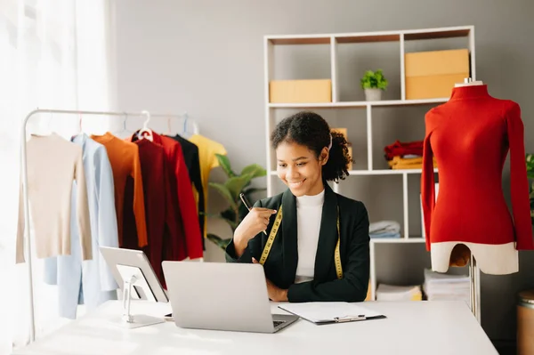 stock image Calm curly brunette, dark skinned woman on desk in modern office of fashion designer and  laptop 