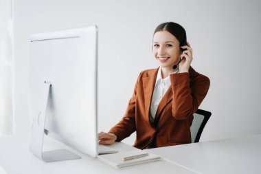 Kablosuz kulaklıklı kadın çağrı merkezi operatörü müşteri destek servisindeki müşteriyle konuşuyor 