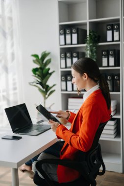 Bir ofis masasında, vergi, rapor, muhasebe, istatistik ve analitik araştırma konseptinde matematik finansmanı yapmak için tablet ve laptop kullanan iş kadını
