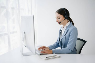 Kablosuz kulaklıklı kadın çağrı merkezi operatörü müşteri destek servisindeki müşteriyle konuşuyor