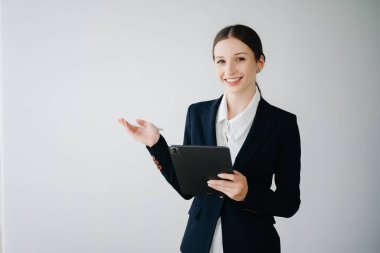 Beyaz arka planda izole edilmiş tablet kullanan Kafkas genç iş kadını