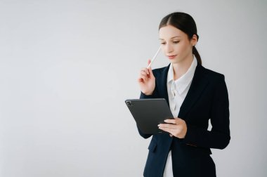 Beyaz arka planda izole edilmiş tablet kullanan Kafkas genç iş kadını