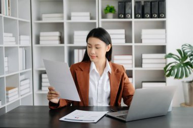 Bir ofis masasında matematik finansmanı, vergi, rapor, muhasebe, istatistik ve analitik araştırma kavramını kullanan iş kadını