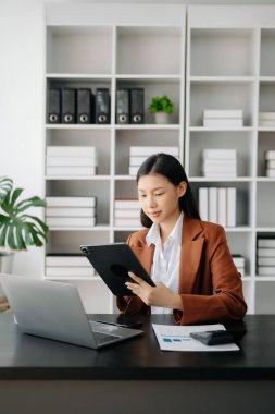 Ofiste tablet ve laptop kullanan iş kadını