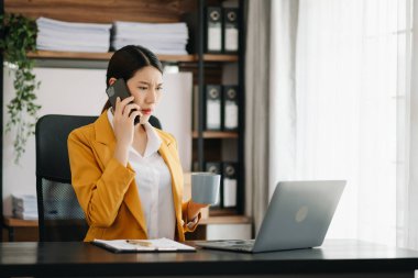 Öfkeli iş kadını modern ofiste telefonla konuşmaktan zevk alır.