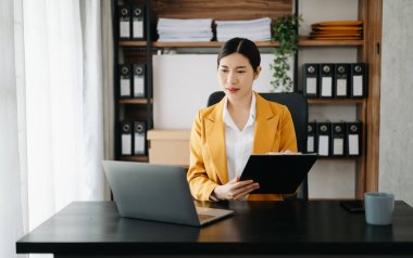 Bir ofis masasında matematik finansmanı, vergi, rapor, muhasebe, istatistik ve analitik araştırma kavramını kullanan iş kadını