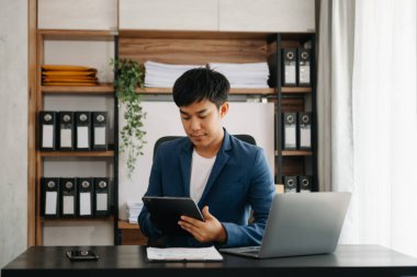 Bilgisayarlı ve tabletli iş adamı yöneticisi online webinar eğitimi izliyor ya da modern ofiste pazar araştırması yaparak sanal toplantı video konferansı yapıyor..