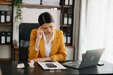 Modern ofiste ofis masası, vergi, rapor, muhasebe, istatistik ve analitik araştırma kavramında matematik finansmanı için dizüstü bilgisayar kullanan yorgun iş kadını