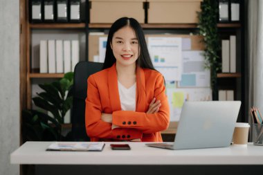 Ofiste dizüstü bilgisayar kullanan Asyalı iş kadını.