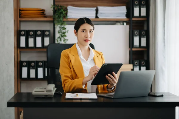 stock image Businesswoman using tablet and laptop for doing math finance on an office desk, tax, report, accounting, statistics, and analytical research concept in modern office