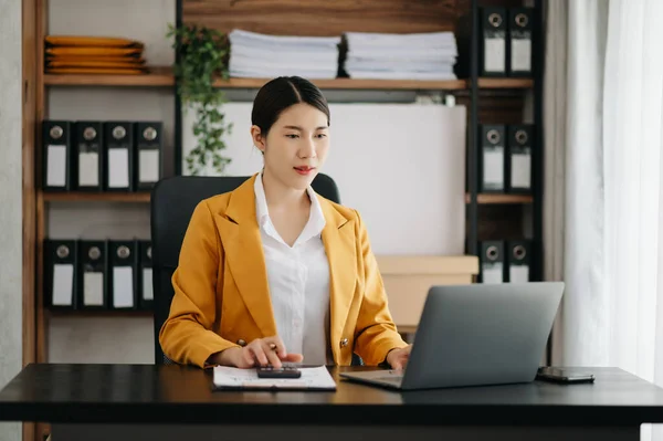 stock image Businesswoman using  laptop for doing math finance on an office desk, tax, report, accounting, statistics, and analytical research concept in modern office