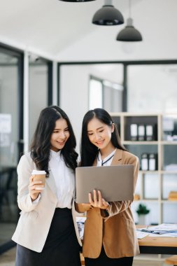 Nazik yönetici yönetici iş çözümlerini paylaşır ve tartışır tablet üzerinde fikirleri modern ofiste Asyalı bayan pazarlama yöneticisi ile birlikte planlar.
