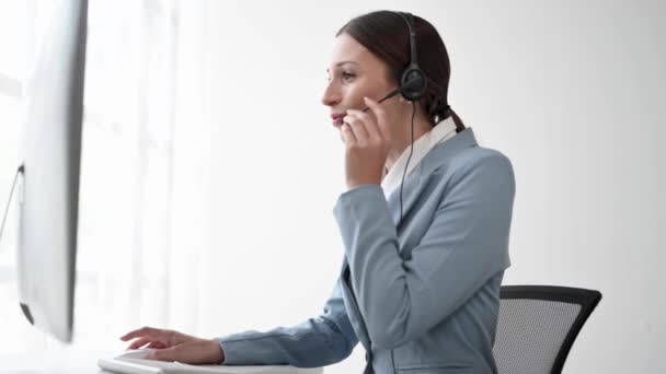 无线耳机中的女性呼叫中心操作员在客户支持服务中与客户交谈 — 图库视频影像