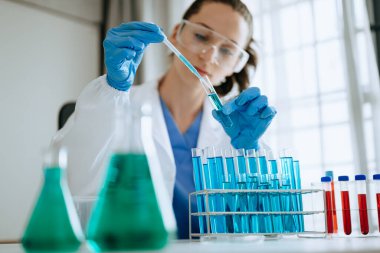 Modern tıbbi araştırma laboratuvarı. Kadın bilim adamı mikro pipetlerle çalışıyor biyokimyasal örnekleri analiz ediyor, tıp için ileri bilim kimya laboratuvarı. 