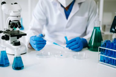 Kimya laboratuvarında kimyasal sıvıları karıştıran bir bilim adamı. Kimya laboratuvarında çalışan bir araştırmacı.