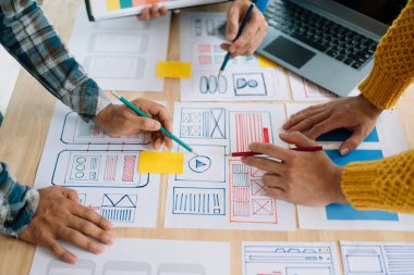 Close up view of UI developer team brainstorming on their project with laptop. Creative digital development agency. in office