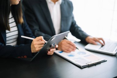 İş ekibi toplantısı. Profesyonel yatırımcı yeni bir başlangıç projesi üzerinde çalışıyor. Ofiste dijital tabletle finans görevi