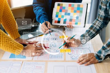  UX geliştiricisi ve ui tasarımcısı modern ofiste müşteri özeti ve renk kodu ile mobil uygulama arayüzü kablo tasarımı hakkında beyin fırtınası yapıyorlar