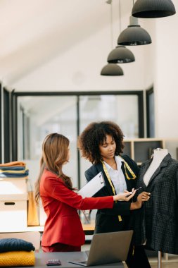 Çeşitli kadın moda tasarımcıları boyunlarında santimetre boyayla iş başında ve not defteri tutuyorlar. bağımsız yaratıcı tasarım işi.