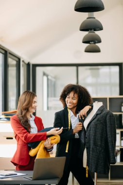 Boyun ve dizüstü bilgisayarlarında terzi ile çalışan çeşitli kadın moda tasarımcıları. bağımsız yaratıcı tasarım işi.