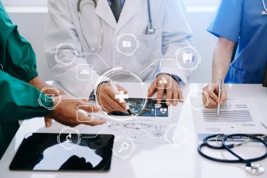 Tıp teknolojisi ekip toplantısı konsepti. Modern dijital tablet ve grafik arayüzü ile çalışan doktorlar