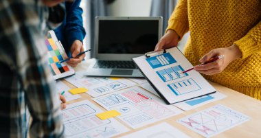 Close up view of UI developer team brainstorming on their project with laptop. Creative digital development agency. in office