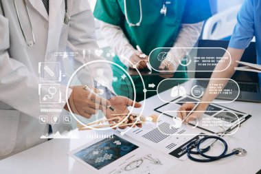 Tıp teknolojisi ekip toplantısı konsepti. Grafik çizelgesi arayüzü olan modern dizüstü bilgisayarla çalışan doktorlar
