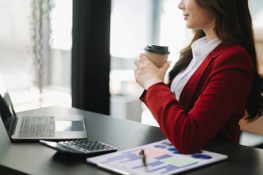 Ofiste kahve içerken kendine güveni tam bir iş kadını ve dizüstü bilgisayar.