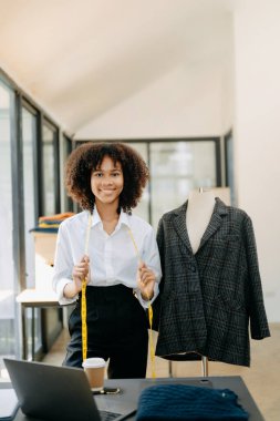 Afrikalı terzi kadın terzide terzilik yapıyor. Stüdyodaki güzel bayan moda tasarımcısı.