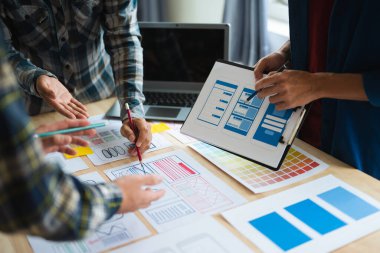 Close up view of UI developer team brainstorming on their project with laptop. Creative digital development agency. in office