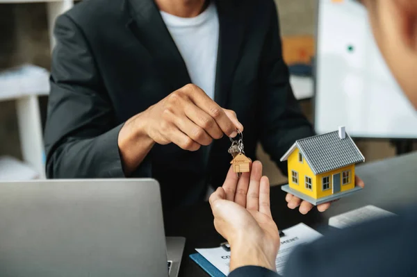 stock image Real estate broker agent presenting and consult to customer to decision making sign insurance form agreement, home model, concerning mortgage loan offer in office