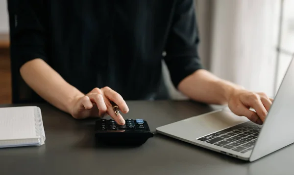 stock image Close up of businesswoman or accountant with laptop ,calculate on desk about cost at home office.