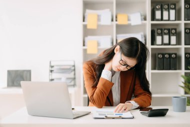 İş yerinde uzun bir gün geçirdikten sonra boynu ağrıyan Asyalı genç iş kadını ofis çalışanı.. 