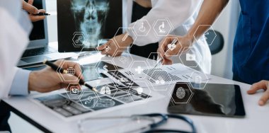 Tıp teknolojisi ekip toplantısı konsepti. Sanal simge diyagramı ve grafik tableti arayüzü olan dijital tablet ve dizüstü bilgisayarla çalışan doktorlar