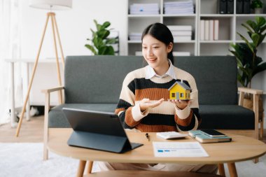 Genç emlakçı, evdeki ofiste ve küçük evde tabletle çalışıyor. 
