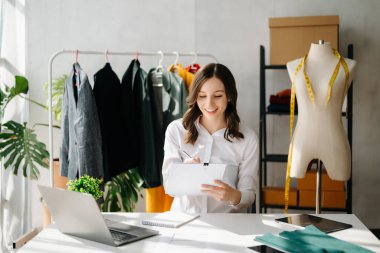 Beyaz kadın, moda tasarımcısı, tablet ve dizüstü bilgisayarı olan. 