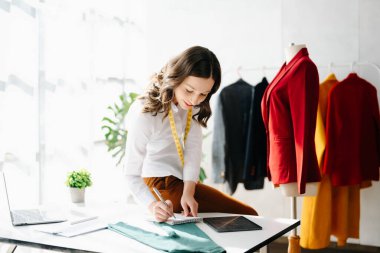 Beyaz kadın, moda tasarımcısı, tablet ve dizüstü bilgisayarı olan. 