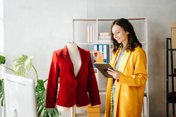 Кавказская молодая женщина, модельер с компьютером и планшетом в офисе