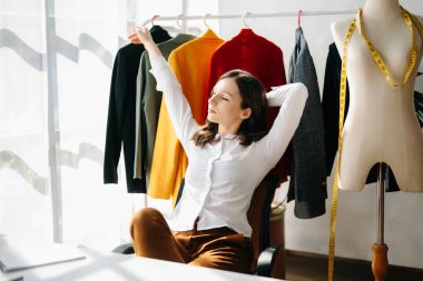Kafkasyalı genç kadın, dizüstü bilgisayarı olan moda tasarımcısı. 