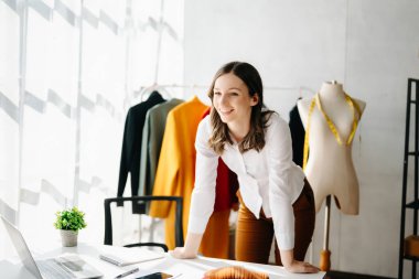 Kafkasyalı genç kadın, dizüstü bilgisayarı olan moda tasarımcısı. 