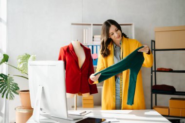 Modern stüdyoda dijital tablet bilgisayarı olan dizüstü bilgisayar kullanan moda tasarımcısı kadın. 