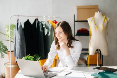 Beyaz kadın, moda tasarımcısı, tablet ve dizüstü bilgisayarı olan. 