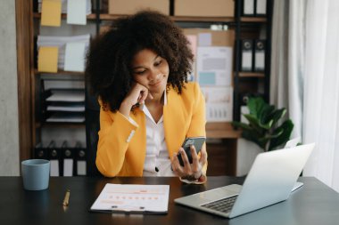  Modern ofiste dizüstü bilgisayarı ve telefonu olan güzel bir iş kadını.